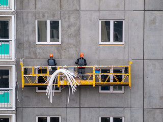 high-rise workers work on the lift in the construction of high-rise multi-storey buildings,...