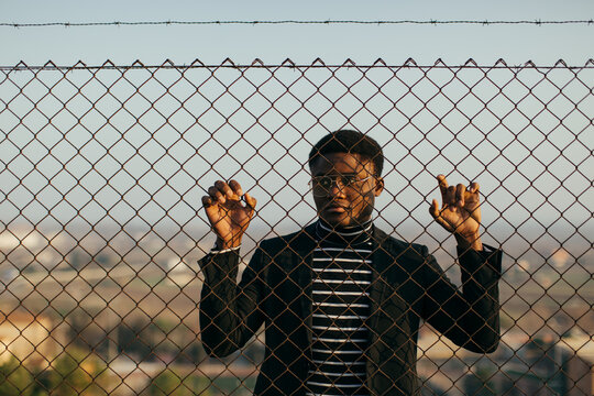 African man behind an iron grid