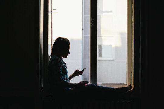 Silhouette of a woman using a mobile phone