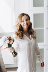 Young beautiful white-skinned Bride with gentle curls in lingerie and boudoir dress posing lying