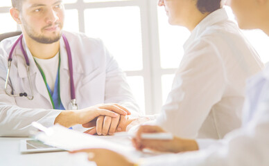 Serious medical team using a laptop in a bright office