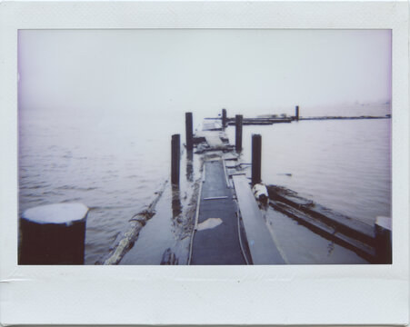 Dock extending out into the ocean water instant f ilm