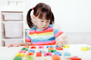 young  girl learning letter blocks for homeschooling
