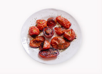 Old porcelain plate with roasted tomatoes isolated on white background.