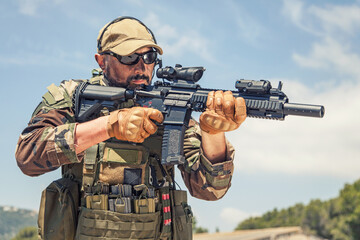 Private military company mercenary, brutal looking special forces fighter in battle uniform and...