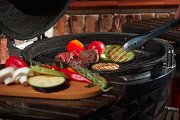Fresh meat and vegetables grilled at a homemade weekend barbecue. Cooking concept, dark kitchen