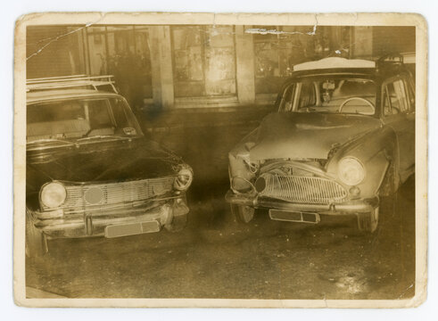 Old photo of two cars that have crashed into each other.