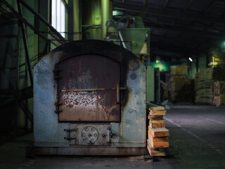 Manufacture of wood pellets. Close-up photo of equipment. Woodworking timber industry: machines and equipment for pressing and cutting sawn timber. Metal oven