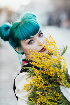 Portrait of a beautiful young woman holding yellow flowers