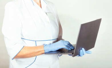 Fototapeta premium Doctor in latex gloves with laptop in hands