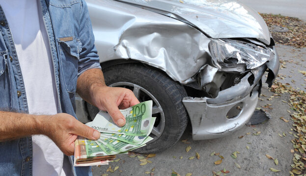 Damaged car inspection, male hands holding money, Euro banknotes, insurance agent or worker, mechanic or car owner