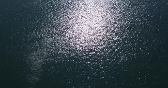 Top View Slow motion looping c ripples and wave, Refraction of sunlight top view texture sea side, Foaming and Splashing in the Ocean, Sunny Day, Slow Motion Video. Veiw from drone