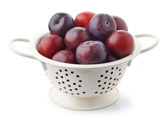 fresh ripe plums in white colander