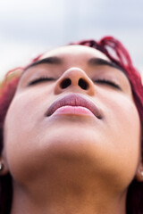 Headshot of black woman with her eyes shut