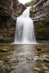 Beautiful place with a waterfall that falls from the rocks of the mountain with the smooth water in long exposure. Tourism in Spain, Catalonia, Barcelona, Osona, Cantonigros, La Foradada.