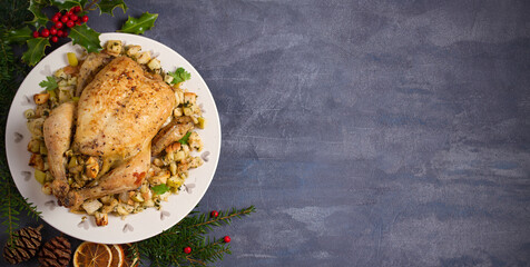 Roasted chicken stuffed with apple bread and celery. Christmas Thanksgiving dinner table. Top view,...