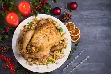 Roasted chicken stuffed with apple bread and celery. Christmas dinner table. Top view, overhead