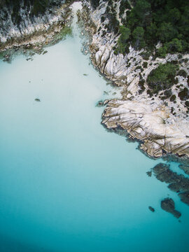 beautiful white rocks and green forest beside crystal clear turqouise sea from above - greece