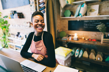 Black woman portrait smiling in a small local shop.