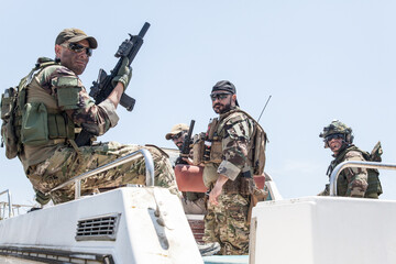 Army special operations soldiers, SEALs team, elite commando fighters group loaded with ammunition,...