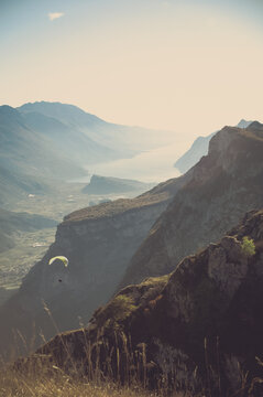 paraglider flying in the mountains with autumnal sunet light