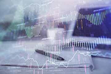 Double exposure of financial graph drawings and desk with open notebook background. Concept of forex market