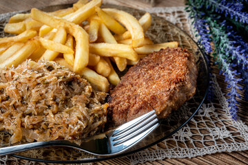 Pork chop in breadcrumbs served with fries and stewed cabbage.