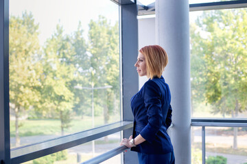 Thoughtful businesswoman looking through window in office