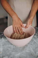 Obraz na płótnie Canvas female hands kneading dough homemade bread bowl