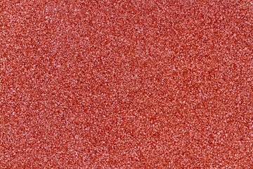 Soft red rubber coating. Rubber crumb coating for safe sports activities on the Playground. Top view of a small crumb of rubber on the Playground.