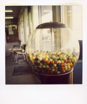 Polaroid Photograph Of Gumballs In A Machine In An Office Building