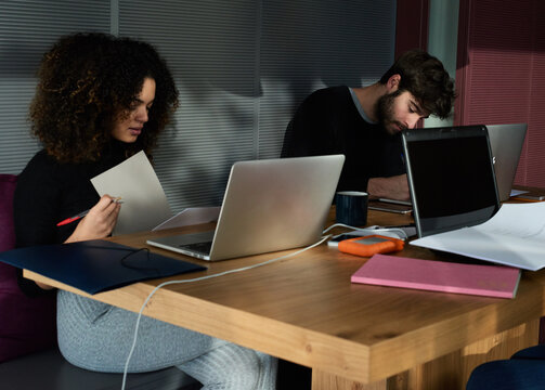 Couple of students studying maths at desk.