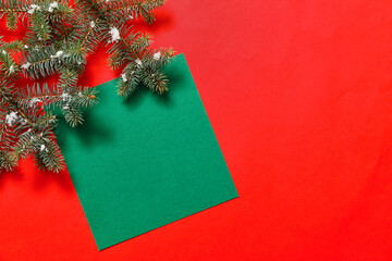 Beautiful Christmas tree branches with empty card on color background