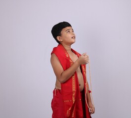 Cute boy in Indian ethnic  wear chanting God's name / jaap. using rosary string of prayer beads or...