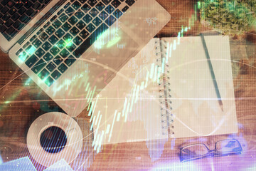 Obraz premium Financial market graph and top view computer on the desktop background. Double exposure. Investment concept.