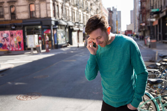 Man in green sweater on a phone