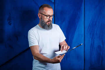 Adult male mentor, director, businessman in glasses and a suit studying documents while sitting at the table. Working day concept