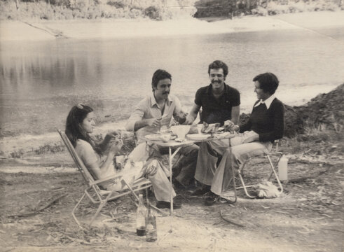Four young people having fun near a river - Vintage film photo