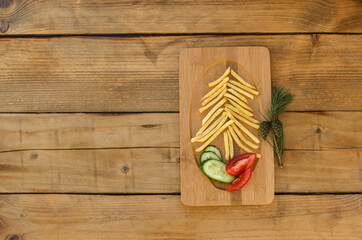 Fast food Christmas on wooden table. Cristmas tree potatoes fries. French fries shape Cristmas tree.  Flat lay