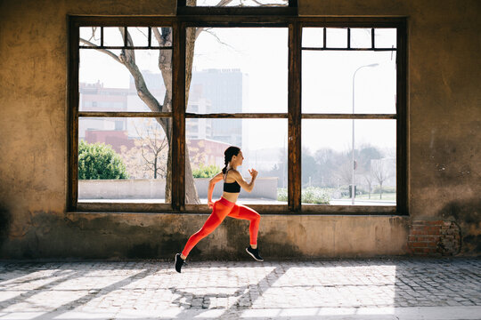 Sporty woman running in the hangar