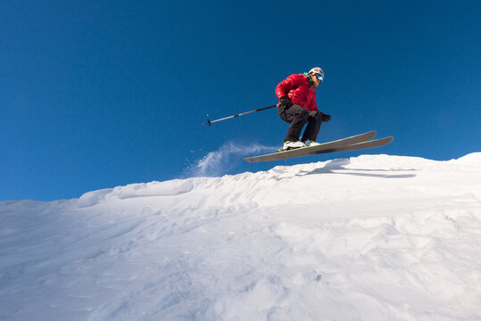 Skier floating in air while riding downhill powder slope