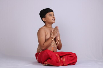 Young boy in Indian ethnic wear praying god. Namaste pose