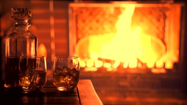 Decanter and glasses of whiskey near the fireplace. Romantic mood