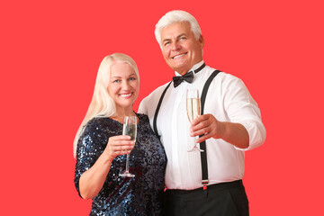 Elderly couple with champagne on color background. New Year celebration