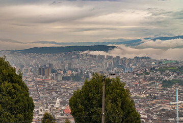 Quito, Ecuador - December 2, 2008: Seen from Cerro El Panecillo down. Wide cityscape with towers...