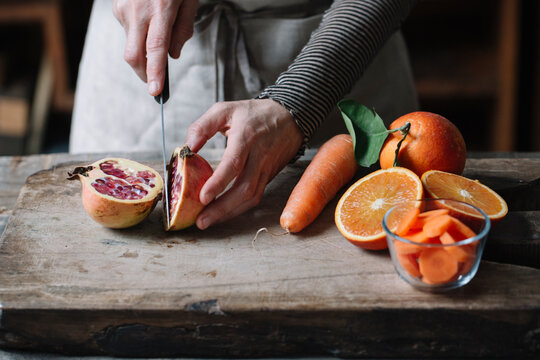Person slicing pomegranate