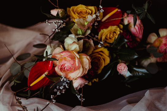 Dark and moody scene of a beautiful organic bouquet of versified flowers