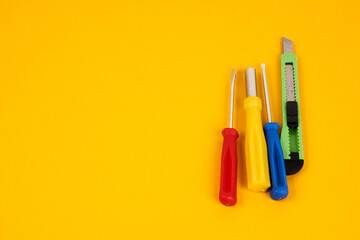 stationery knife screwdrivers and construction tools on yellow background equipment for repair industry