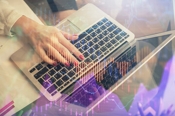 Double exposure of woman hands typing on computer and financial graph hologram drawing. Stock market analysis concept.