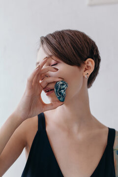 Unusual portrait of a beautiful female with a clay ear in her hand